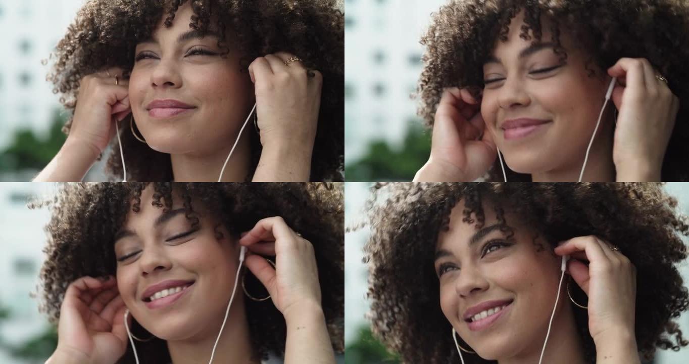 4k视频片段，一个美丽的年轻女子戴着耳机站在城市外面