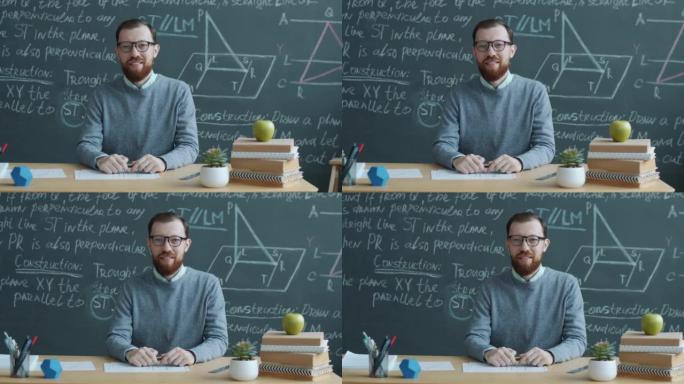 大学教授坐在课桌前的肖像，背景是黑板