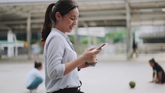 亚洲女商人使用智能手机手持户外散步咖啡