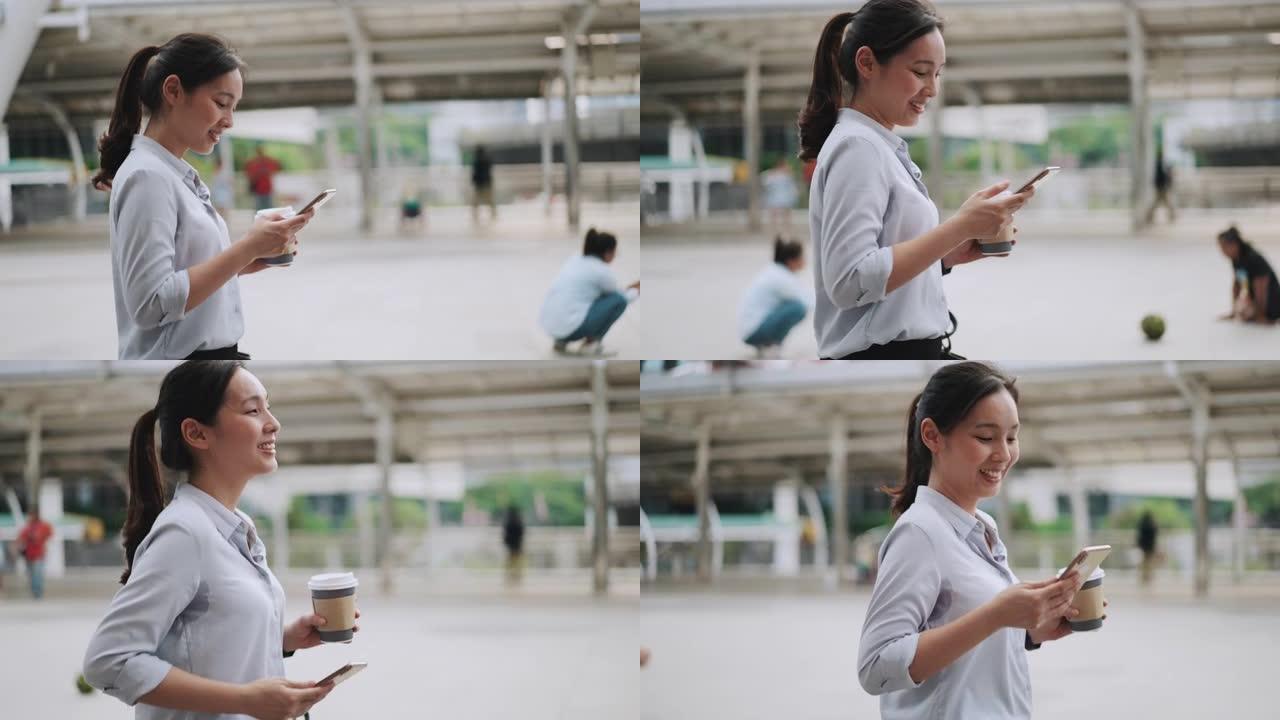 亚洲女商人使用智能手机手持户外散步咖啡