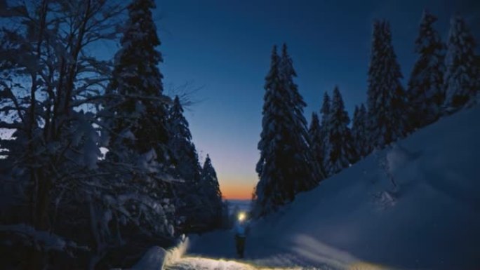 SLO MO徒步旅行者带着头灯在积雪覆盖的乡间小路上行走