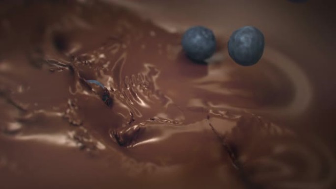 蓝莓在4k超级慢动作中落入液体巧克力中