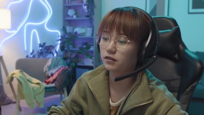 年轻的中国女玩家在电子游戏中得分并欢呼