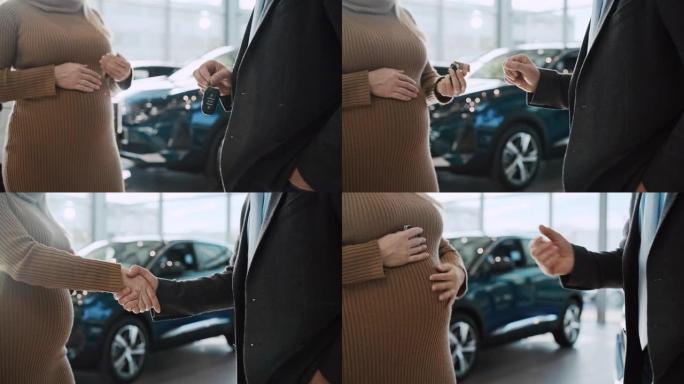 SLO MO汽车推销员将新车的钥匙交给了孕妇