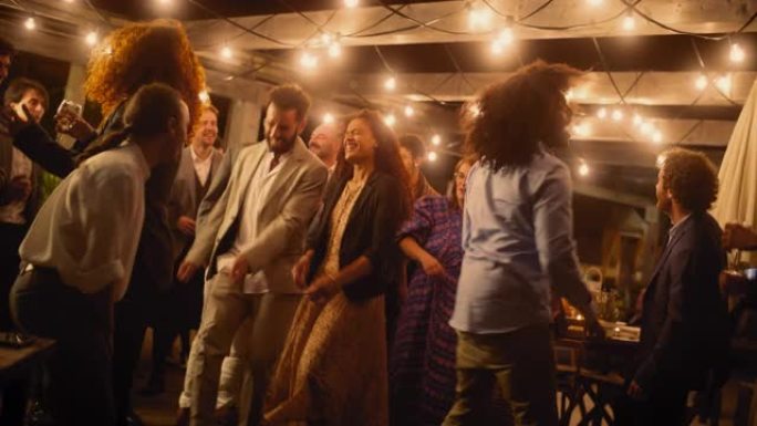 美丽的无忧无虑的朋友一起跳舞，并在聚会上庆祝晚间活动。多元化的多民族年轻人在餐厅的公司聚会上玩得开心