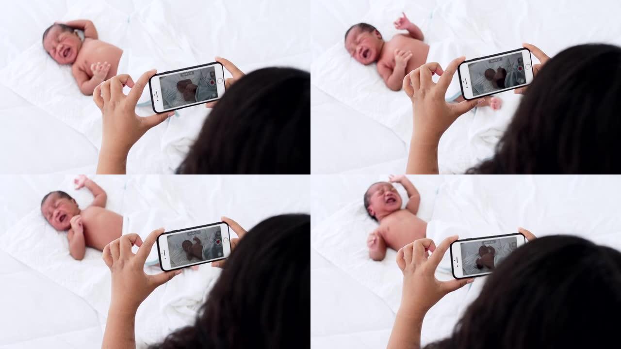 母亲在床上为他的新生儿拍照