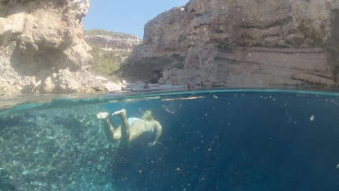 年轻女子女士在克罗地亚阳光明媚的亚得里亚海水下游泳