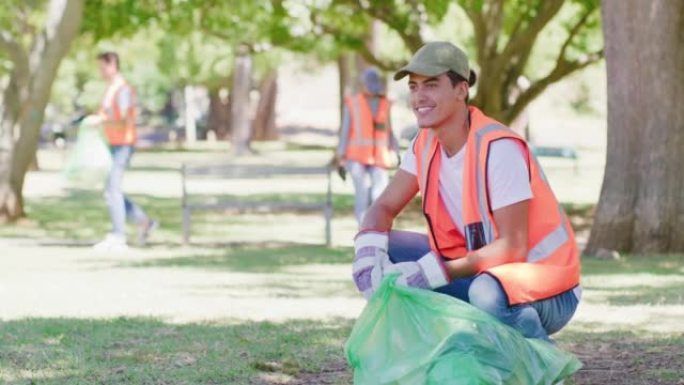 快乐的年轻人在一个生态友好的社区打扫公园。负责任的理事会工作人员，活动家或志愿者收集垃圾和垃圾，以建