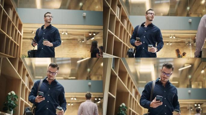 一个白人男子手里拿着智能手机和咖啡走在公司办公室的肖像。一位商人在早上走向办公桌开始工作时微笑着