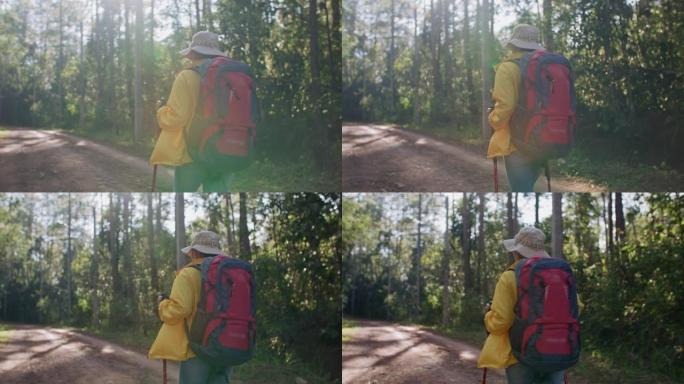 穿着黄色雨衣的女徒步旅行者和背包