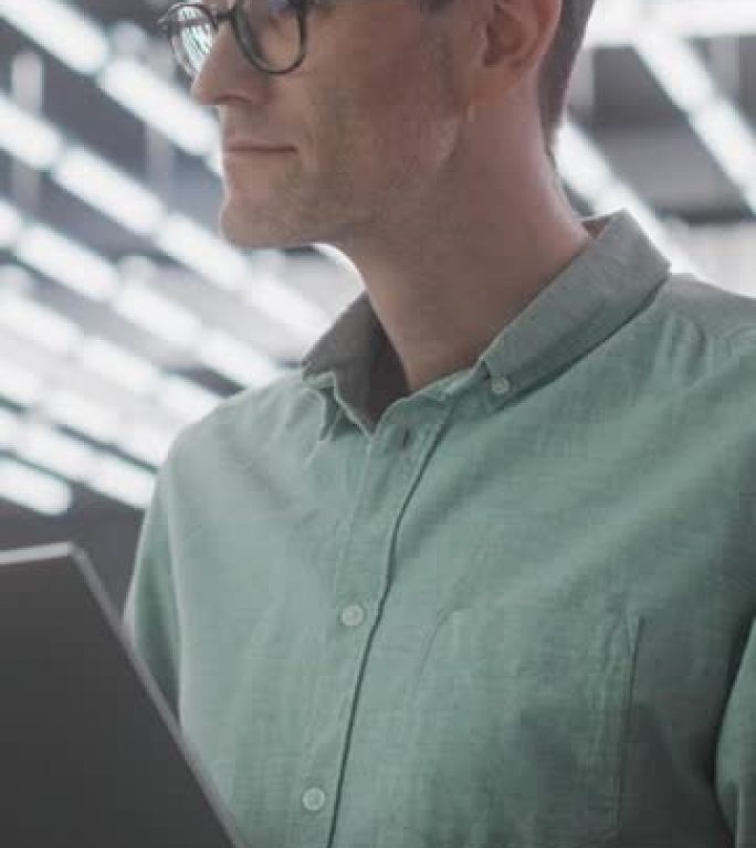 垂直屏幕: 使用笔记本电脑戴眼镜的自信白人男性的肖像。成功经验丰富的专业人员在国际技术公司办公室在线