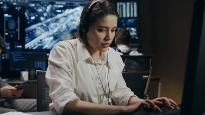 一位穿着白衬衫的年轻女子正在电脑前工作