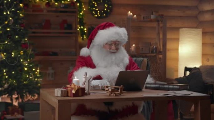 圣诞老人正在笔记本电脑上输入一封带有各种面部表情的信