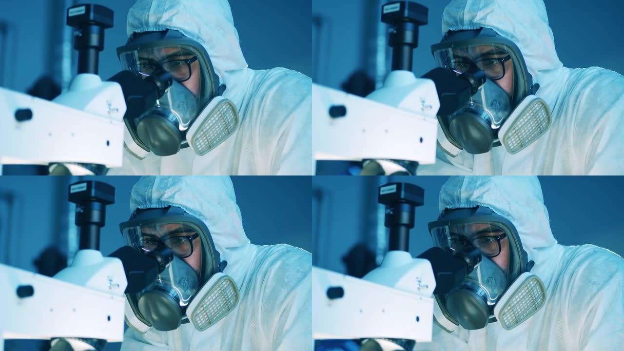 穿着防溅服的男科学家正在显微镜下观察