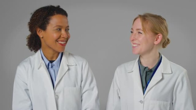 两名穿着白大褂微笑的女医生或实验室工作人员的工作室肖像
