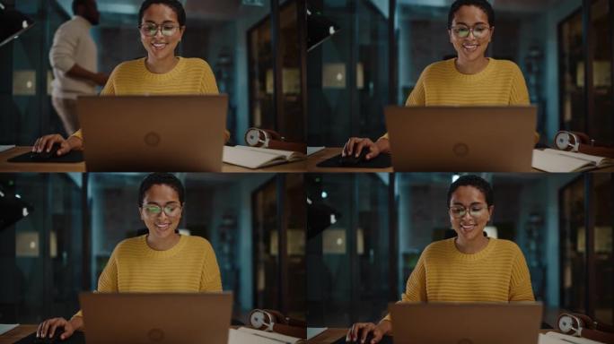 在繁忙的创意办公环境中，年轻的西班牙裔营销专家在笔记本电脑上工作。美丽多样的多民族女性项目经理正在浏