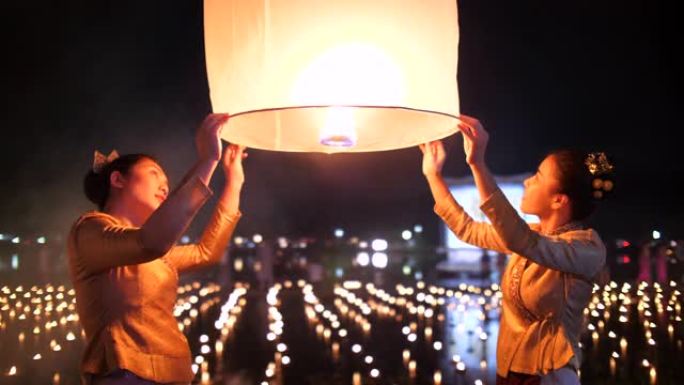 在Loi kathong节中祈祷和释放灯笼的年轻女子