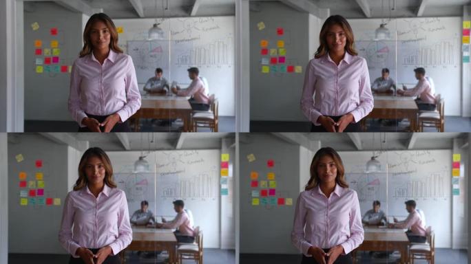成功的女性商业领袖在营销办公室面对镜头时看起来非常自信