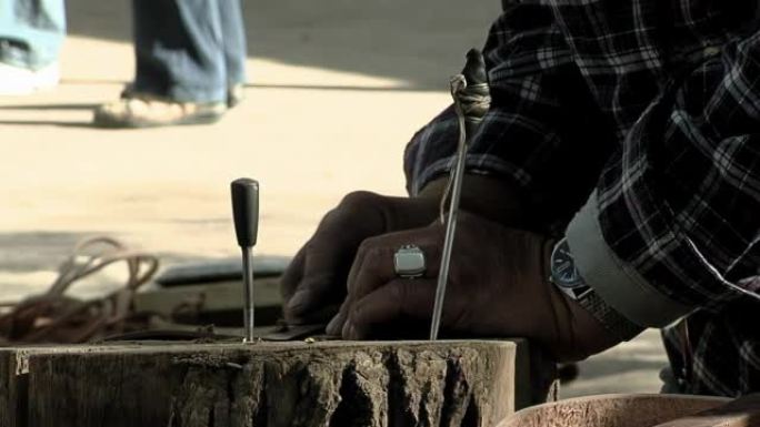 男子在制作 “Bombo Leguero” 时在行李箱上工作，这是一种用木头和动物皮革制成的阿根廷鼓