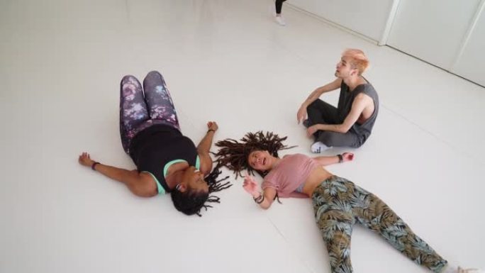在健身工作室进行舞蹈锻炼后，精疲力尽的人在地板上休息