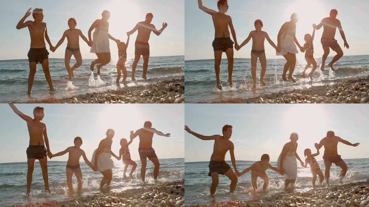 超级SLO MO家庭有三个孩子在日落时在海滩上跳跃