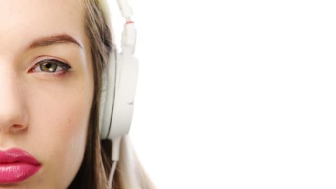 一名年轻女子在白色演播室背景下使用耳机的4k视频片段