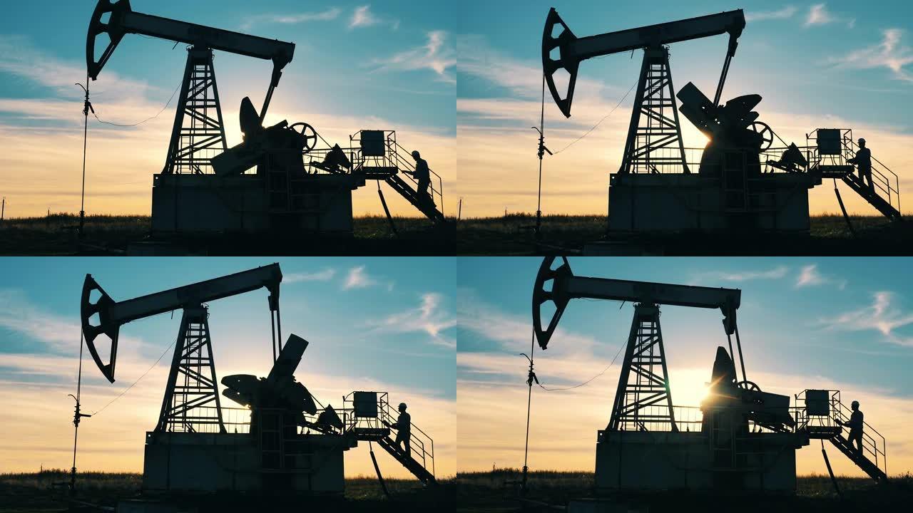石油工业工人走上油田的油泵