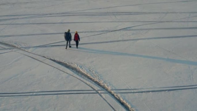 在冰冷的湖中行走的两个旅行者的上方视图