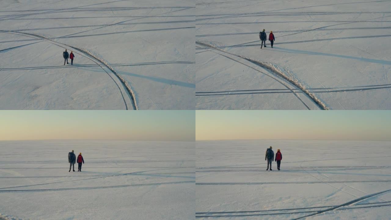 在冰冷的湖中行走的两个旅行者的上方视图