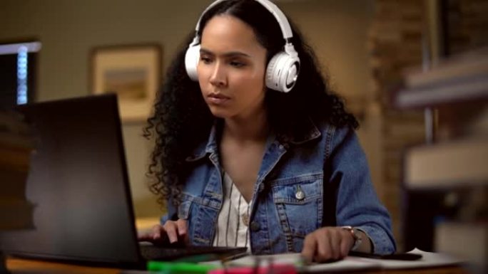 年轻女子在家学习，用无线耳机听音乐。女学生阅读学习教材，使用笔记本电脑为考试做准备。专注于教育的远程