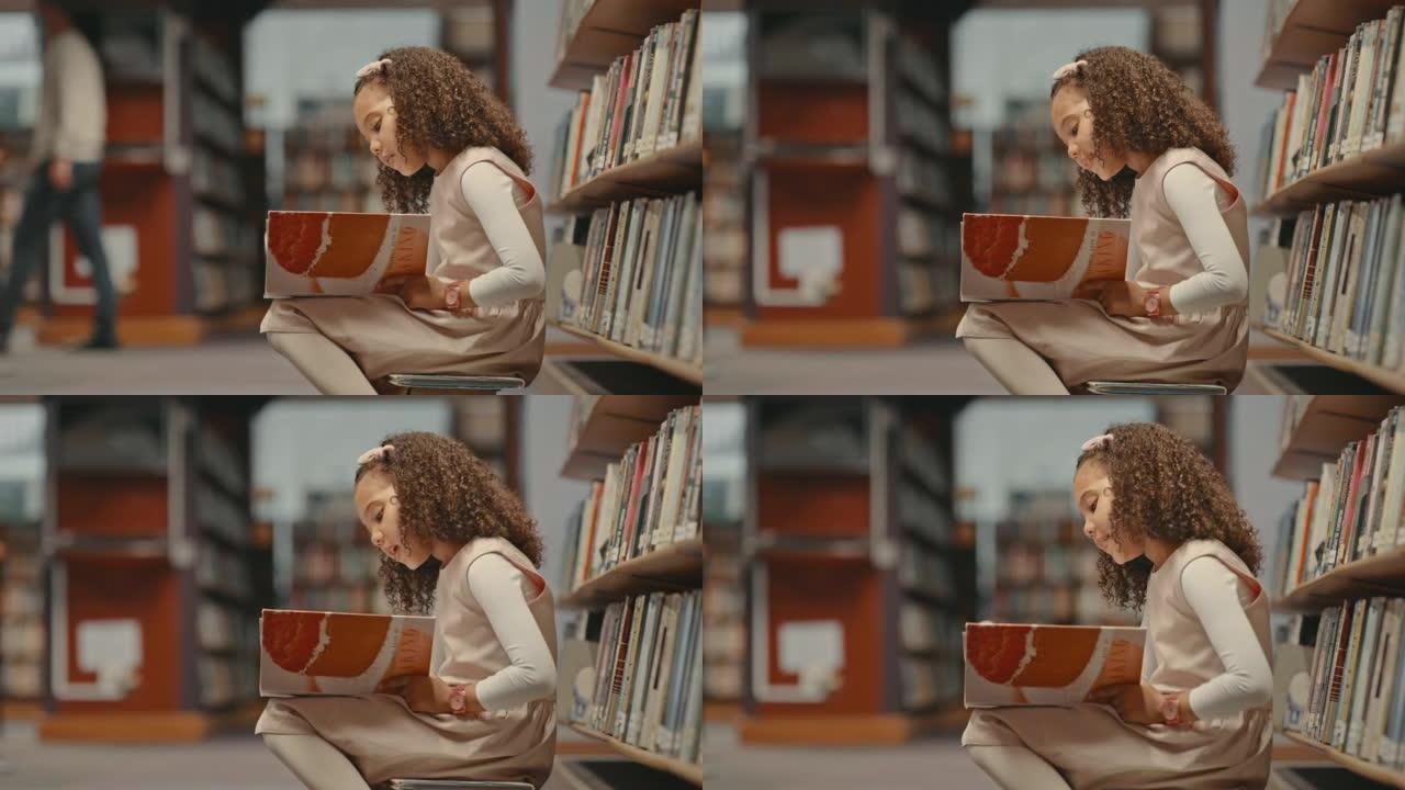 小女孩独自在图书馆。做研究的小孩。可爱的孩子在图书馆做她的学校工作。