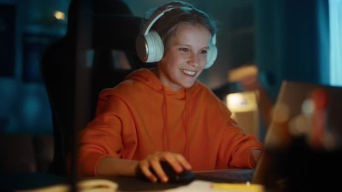 兴奋的小男孩在家里舒适的黑暗房间里，戴着耳机在笔记本电脑上玩视频游戏。快乐成功的少年击败玩家并在在线
