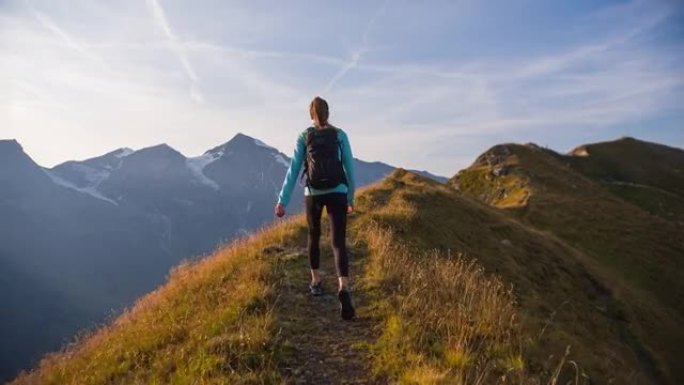 年轻的健身女子保持健康，在山上高高的空气，沿着山脊走