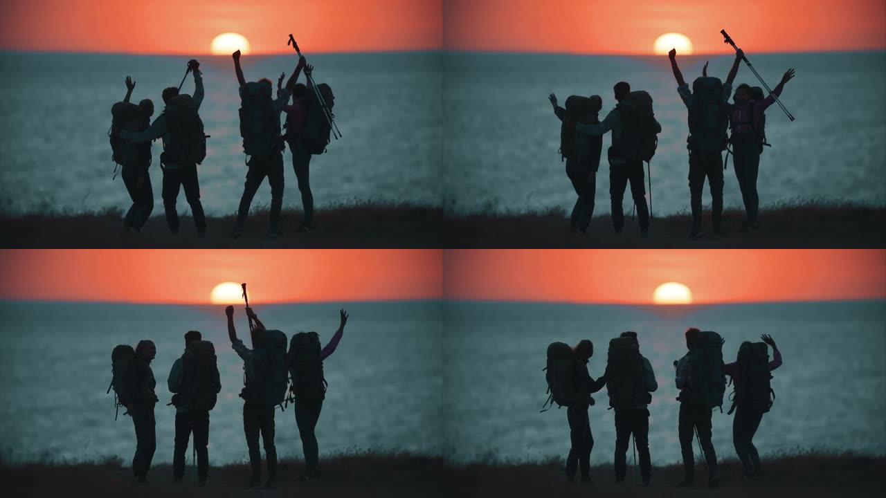 这四个旅行者在日落背景下的海边玩得很开心。慢动作