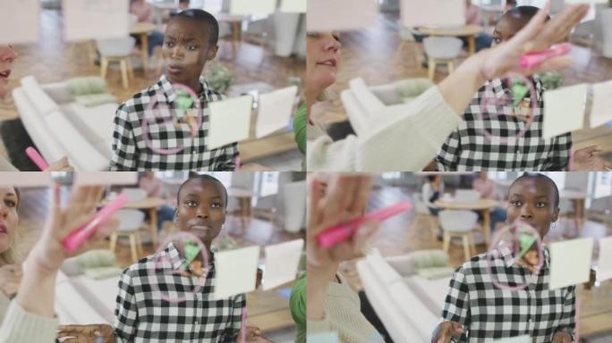 多元化的女性商业同事在玻璃墙上讨论备忘录