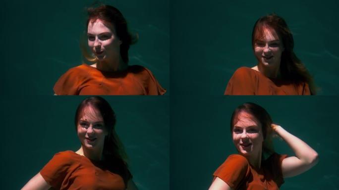 电影特写肖像，美丽的年轻幸福的女人摆姿势，微笑着穿着波西米亚服装潜水水下慢动作。