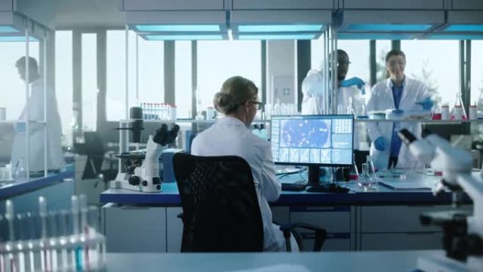 医学实验室与科学家团队一起工作。微生物学家在显微镜下观察并在计算机上工作。开发药物、基因编辑、高科技