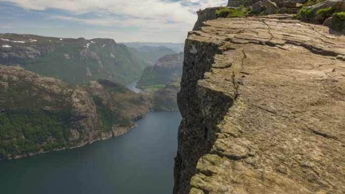 镜头沿着悬崖边缘移动。山脉和峡湾的背景。牧师椅悬崖，又名布道石，挪威。万向节HDR照片