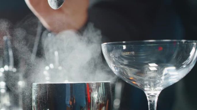 专业调酒师的特写镜头正在酒吧或迪斯科俱乐部为顾客准备精英酒精鸡尾酒。