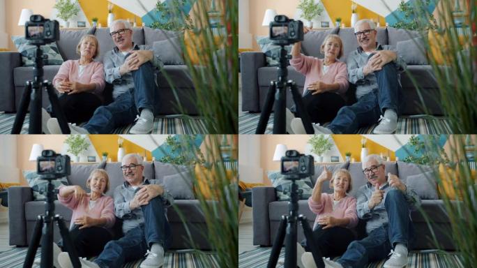 高级男人和女人vlogger录制视频，显示在家中使用相机竖起大拇指
