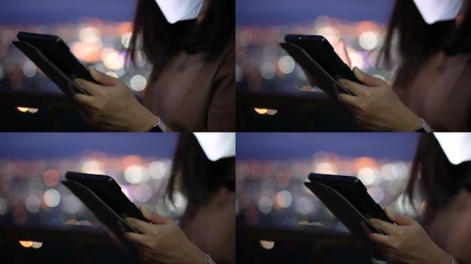 女人在晚上使用电话与城市的circle light bokeh