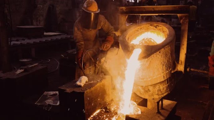 工厂工人在铸钢铸造厂将熔融金属倒入铸件的特写正视图