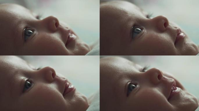可爱的蓝眼睛新生男婴躺在托儿所的婴儿床里看着微笑。孩子，婴儿，父母身份，童年，生活，家庭，未来的概念