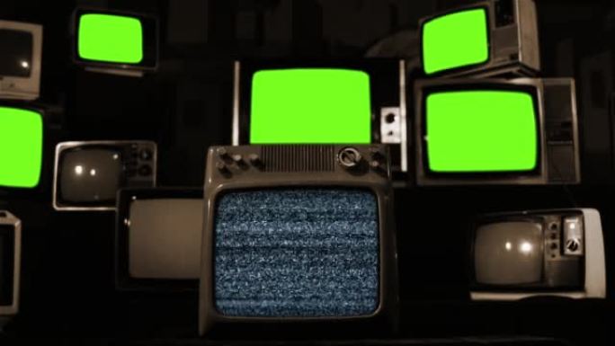 一堆复古电视打开和关闭绿色屏幕。棕褐色色调。