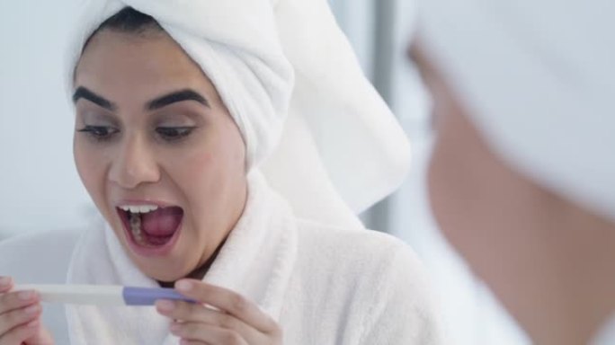 4k视频片段，一名年轻女性在家里的浴室里阅读怀孕测试