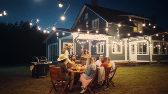 一群多民族的人玩得开心，互相分享故事，在户外晚宴上吃饭。在一个温暖的夏日傍晚，家人和朋友聚集在他们的