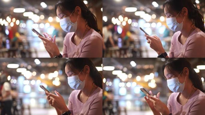 亚洲女性使用带面罩的智能手机