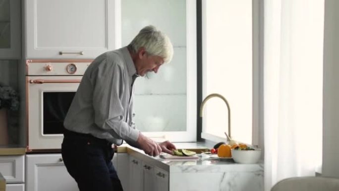 老人在现代厨房里独自做饭时跳舞
