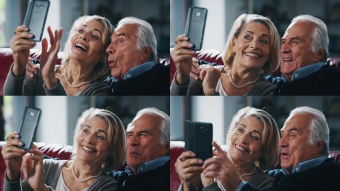 快乐成熟的高级夫妇的特写镜头是在客厅用智能手机自拍。