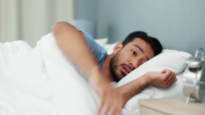 周一早上醒来的床上有闹钟的疲惫的人精神卫生，健康和健康的生活方式。年轻的亚洲年轻人在卧室公寓里早早醒